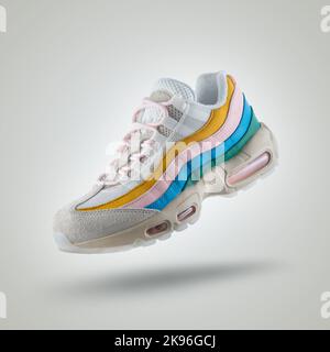 White sneaker with a diversity of colors, shoe on a white gradient background, Yellow, pink, blue, green Stock Photo
