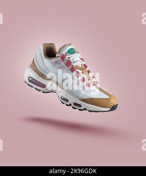 White sneaker with colored accents on a pink gradient background, fashion, sport shoe,  air, sneakers, lifestyle, concept, product photo,  levitation Stock Photo