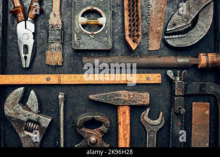 Old hardware tools. Wrench, screwdriver, measure, hammer, pliers on steel surface. Mechanic tools for maintenance. Hardware tools to fix Stock Photo