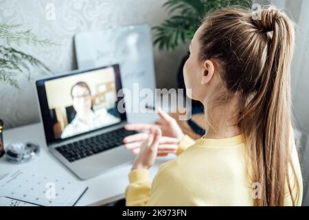 Young woman business woman student teacher tutor having online virtual video call. Freelancer having video conference calling on laptop computer talk Stock Photo