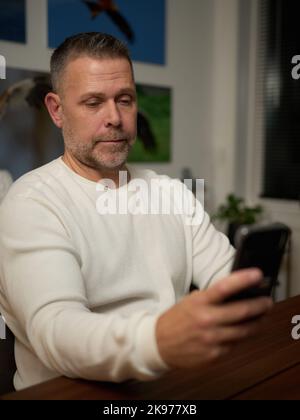 Middle aged man looking at his mobile phone Stock Photo