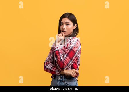 Oh no. Portrait of chinese lady touching mouth with hand and looking at camera, emotionally reacting to bad news Stock Photo