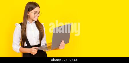 cheerful child study online. computer vision syndrome. nerd typing school blog. School girl portrait with laptop, horizontal poster. Banner header Stock Photo