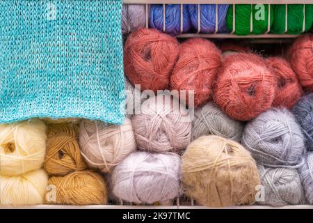 Fluffy skeins of mohair, yarn for knitting and knitted piece, shelf in store. Sale of goods for creativity and needlework Stock Photo