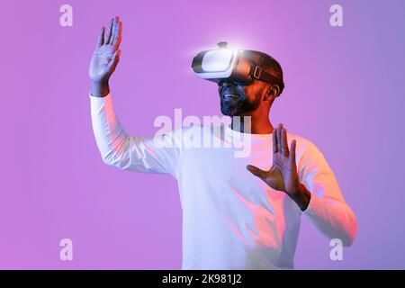 Man in vr glasses, trying to touch something with hands Stock Photo