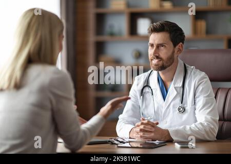 Handsome Male Doctor In Uniform Having Meeting With Female Patient In Office Stock Photo