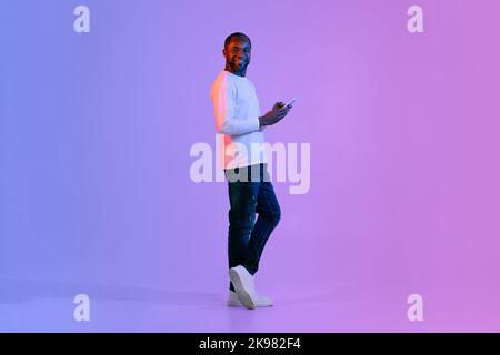Cheerful black man using smartphone and smiling Stock Photo