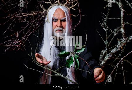 Devil man on Halloween night. Bearded male in witcher costume. Sinister sorcerer vampire. Horror. Stock Photo