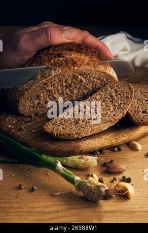 men's hands cut bread with a knife Stock Photo