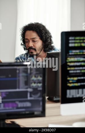 Indian software developer coding on computer in office if IT company Stock Photo