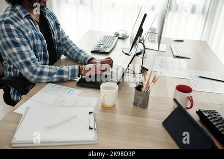 Cropped image of software developer programming on laptop at office desk Stock Photo