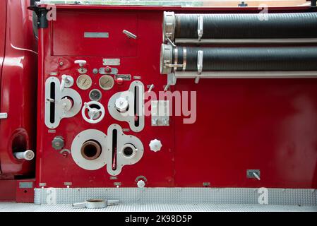 The control panel on a firetruck with industrial pressure gauges, measuring instruments, parts, and valves with alarm buttons for equipment. Stock Photo
