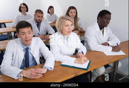 People in white coats in boardroom Stock Photo
