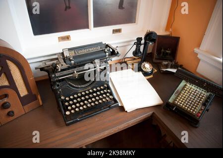 Antique desk with Underwood typewriter, telephone, radio and adding machine in a display at the Dunedin Historic Museum in Dunedin, Florida, USA Stock Photo