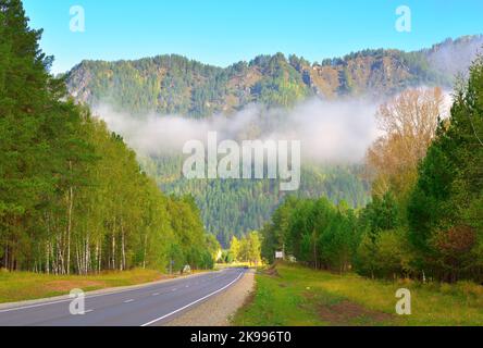 Chuisky tract in the Altai mountains. White clouds over an empty highway in the morning among green mountains. Altai, Siberia, Russia, 2022 Stock Photo