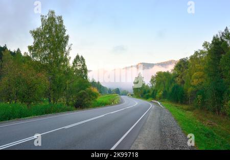 Chuisky tract in the Altai mountains. An empty highway on a foggy autumn morning, clouds in the mountains. Altai, Siberia, Russia, 2022 Stock Photo