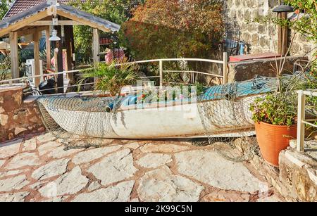 Kayak boat with flowers inside and fishing net to decorate the exterior of the cafe Stock Photo