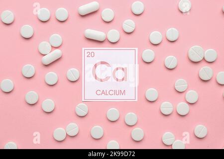 Calcium pills on pink background Stock Photo