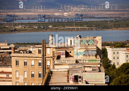 Port town Cagliari capital city of the Italian Mediterranean   island of Sardinia. graffiti, dock cranes and windfarm Stock Photo