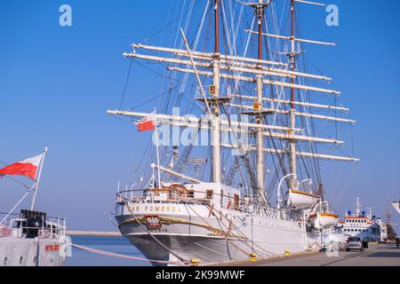 Gdynia Poland May 2022 Flag of Poland waving on flag pole of ship. Polish flag fluttering while sailing boat on sea. Sunny day Stock Photo