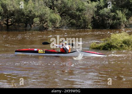 A protected competitor driving a boat on a river Stock Photo