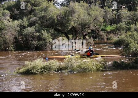 A protected competitor driving a boat on a river Stock Photo