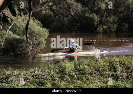 A protected competitor driving a boat on a river Stock Photo