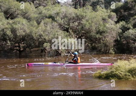 A protected competitor driving a boat on a river Stock Photo