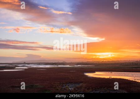 Moody stormy colourful sunset skies over Rye Harbour nature reserve on the East Sussex coast south east England Stock Photo