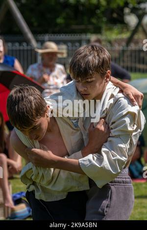 Two young teenagers brothers competing in the Grand Cornish Wrestling Tournament on the picturesque village green of St Mawgan in Pydar in Cornwall in Stock Photo