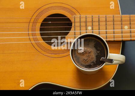 wooden guitar and a cup of coffee on a dark background Stock Photo