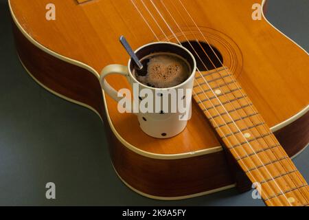 wooden guitar and a cup of coffee on a dark background Stock Photo