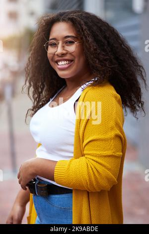 Yes, Im the citys very own. Cropped portrait of a happy young woman standing outdoors in an urban setting. Stock Photo