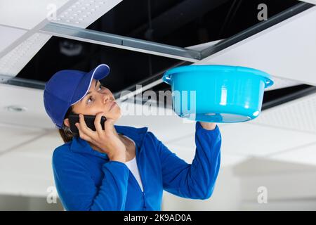 builder woman calling insurance about water leaks Stock Photo