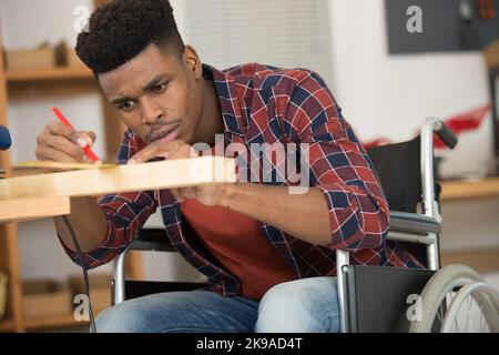 disabled man working with wood in workshop Stock Photo
