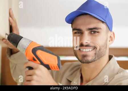 close portrait of young tradesman using drill Stock Photo