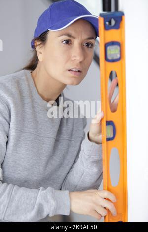 female builder using a spirit level Stock Photo