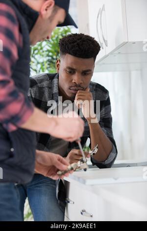two men installing a new kitchen Stock Photo