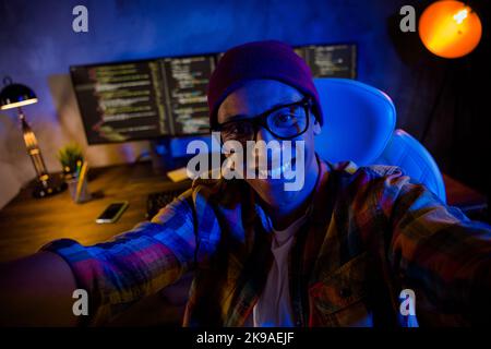 Photo of smiling intelligent hacker guy sit chair make selfie operating server night shift indoors Stock Photo