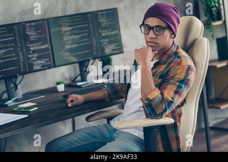 Photo of thoughtful serious freelancer wear hat glasses thinking game code developing indoors workplace workstation loft Stock Photo