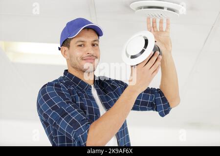 young male technician repairing air conditioner indoors Stock Photo