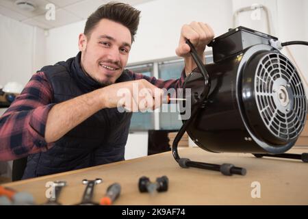 male electrician repairing an appliance Stock Photo