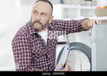 close-up of professional handyman repairing washing machine Stock Photo
