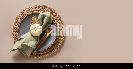Thanksgiving day banner with autumn table setting, white pumpkin, gray plate in natural colors on beige background. Top view. Stock Photo