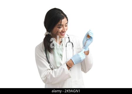 Young Venezuelan female doctor preparing a dose of a vaccine, isolated. Stock Photo