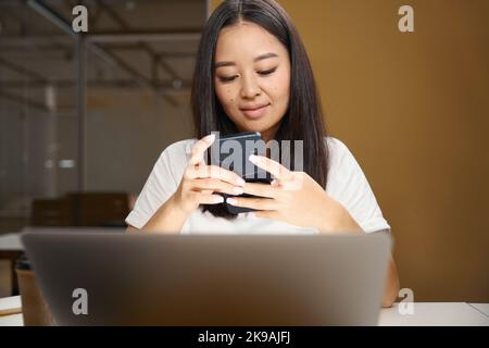 Asian entrepreneur with mobile phone is reading email in conference room Stock Photo