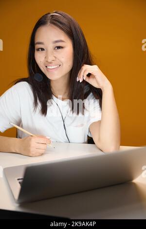 Elegant stylish cute woman with laptop is taking notes in the room indoors Stock Photo
