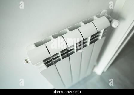 Metal radiator with adjustable valve inside the apartment. Stock Photo