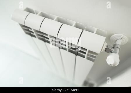 Metal radiator with adjustable valve inside the apartment. Stock Photo