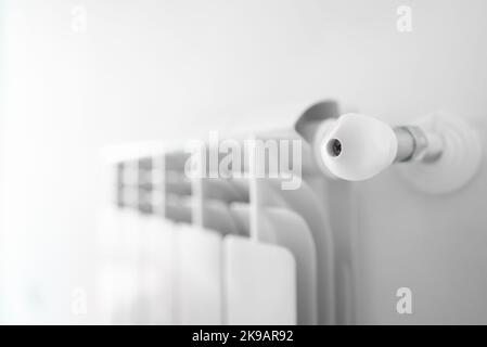 Metal radiator with adjustable valve inside the apartment. Stock Photo